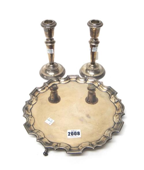 A silver salver, in a shaped circular design, having a pie-crust rim in the Chippendale style and raised on three feet, diameter 26cm, weight 642 gms