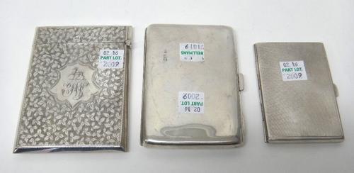 A silver rectangular visiting card case, with foliate engraved decoration, centred by a crest above a monogram, Birmingham 1904, a silver rectangular