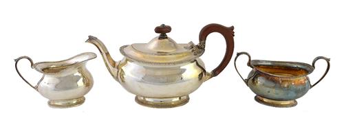 A silver three piece tea set, comprising; a teapot, a twin handled sugar bowl and a milk jug, each piece of oval form, decorated with beaded rims, Bir