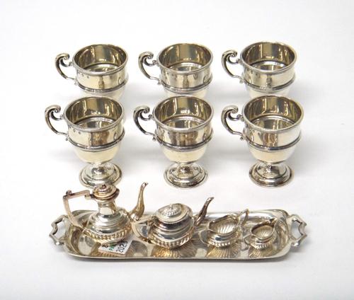 A silver miniature five piece tea service, Birmingham 1958, together with six tot-cups with reeded borders and scroll handles, Edinburgh 1906, gross w