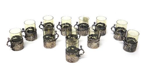 A set of twelve silver and glass spirit tots, the pierced silver frames with embossed putti, Birmingham 1885, bearing mark of William Comyns.