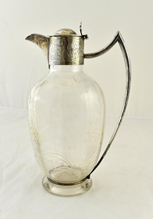 A Victorian silver mounted glass claret jug, the body of oval form, decorated with butterflies and a bird, otherwise with plant life, the mount with s