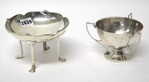 An Art Nouveau silver bonbon dish raised on four legs, with pad feet and a wavy rim border, Sheffield 1911, together with a silver three handled bowl