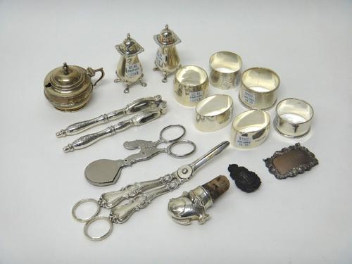 Silver, comprising; a pair of Victorian grape scissors (the hallmark unclear), a pair of pepperettes, Birmingham 1963, a mustard pot, with a blue glas