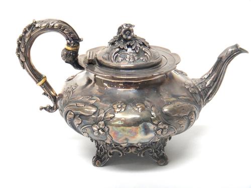 A Victorian silver teapot of squat melon form, with embossed floral decoration and scroll handle, London 1840, 872gms.