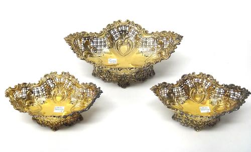 A Victorian silver gilt bonbon basket of shaped oval form, together with two smaller baskets, each with pierced decoration and floral rims, London 189