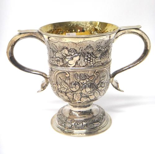 A George III silver twin handled loving cup, with later embossed decoration and presentation inscription, London 1769, 16cm high, gross weight 580gms.