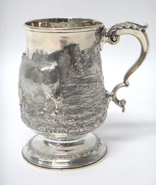 A George III silver mug, with later embossed decoration and presentation inscription, Newcastle 1796, 14cm high, gross weight 384gms.