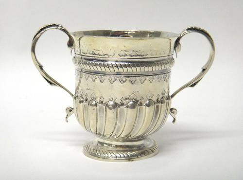 A George I Britannia silver twin handled porringer, with later embossed decoration and presentation inscription, London 1716, 11cm high, gross weight