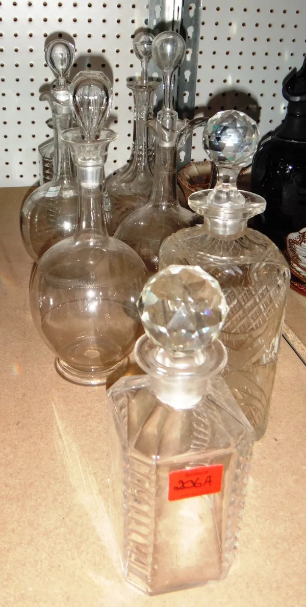 A group of seven assorted glass decanters.