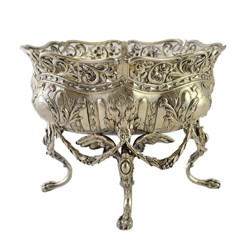 A German silver basket of shaped circular form, with pierced floral rim, raised on four griffin scroll feet, initial and crest engraved, 21cm diameter