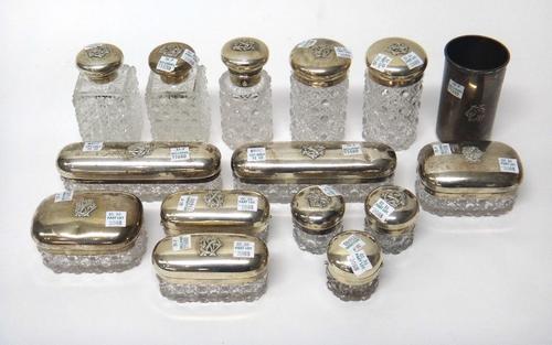 Fourteen Victorian silver mounted cut glass toilet bottles, boxes and jars, the covers decorated with applied monograms, London 1873 and 1874 and a ma