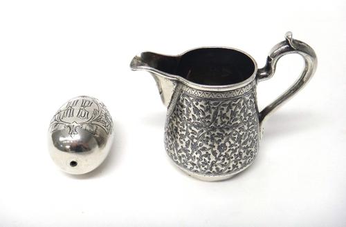 A Russian niello decorated milk jug, St Petersburg 1878 and a Russian travelling egg cup, with two stands, engraved with birds and flowers.