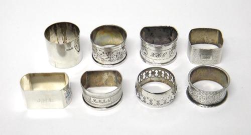 A Victorian silver napkin ring, with engraved decoration within beaded edges, Birmingham 1887, six further silver napkin rings, in a variety of design