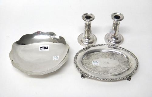 A Mexican shaped circular dish, raised on a cast footrim, diameter 18cm, a pair of silver loaded small candlesticks, on circular bases, the hallmarks