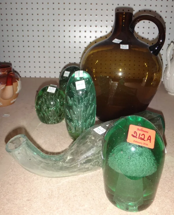 A group of four green glass dump weights, a green glass jug and a medical glass bottle.