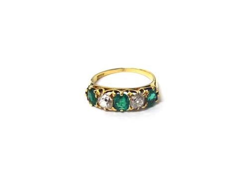 A gold, emerald and diamond set five stone ring, mounted with three cushion shaped emeralds, alternating with two cushion shaped diamonds, the mount d