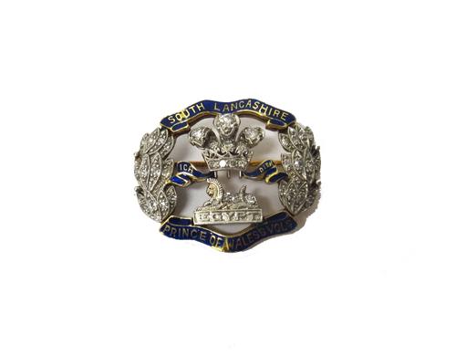 A diamond set and enamelled military sweetheart's brooch, designed as the badge of The South Lancashire Regiment, mounted with circular cut diamonds a