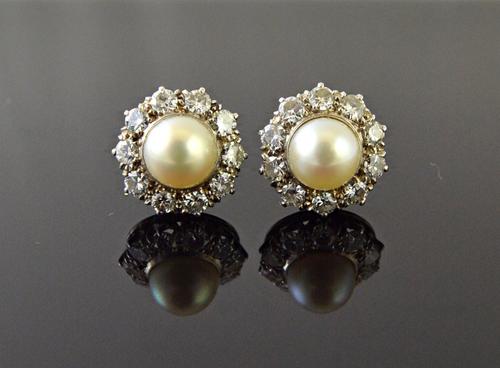 A pair of white gold, diamond and cultured pearl set cluster earstuds, each mounted with a cultured pearl at the centre, in a surround of ten circular