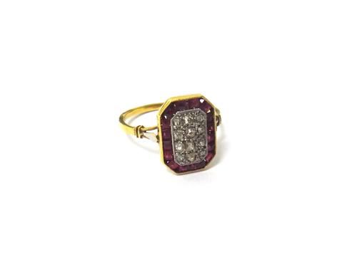 A French gold, diamond and synthetic ruby set ring, in a cut cornered rectangular panel shaped design, mounted with twelve cushion shaped diamonds at