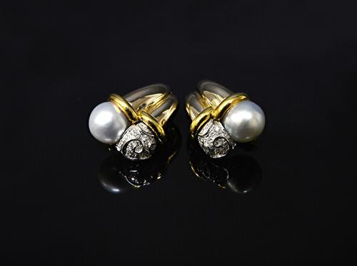 A pair of gold, diamond and cultured pearl set earclips, each in a twin cornucopia shaped design, mounted with a single cultured pearl and otherwise s