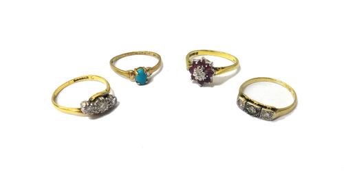 An 18ct gold, ruby and diamond set nine stone cluster ring, a gold and platinum, diamond set three stone ring, mounted with circular cut diamonds in a
