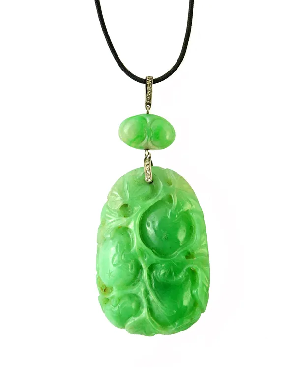 A Chinese carved jade and diamond set pendant, the principal drop carved and pierced with foliage and fruit and with a smaller jade oval bead above, t