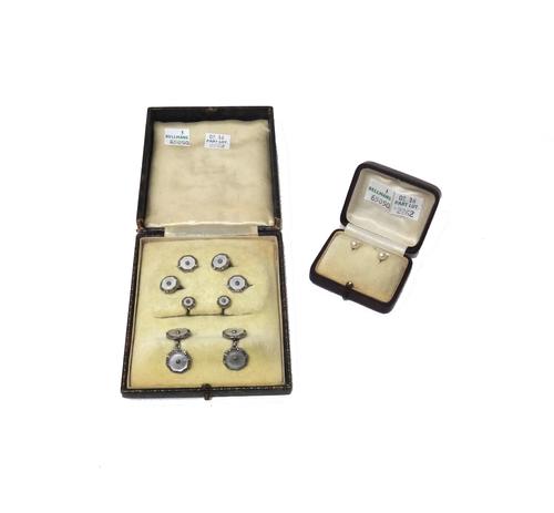 A pair of gold and diamond set single stone dress studs, each mounted with a cushion shaped diamond, on a beaten ground, gross combined weight 7.6 gms