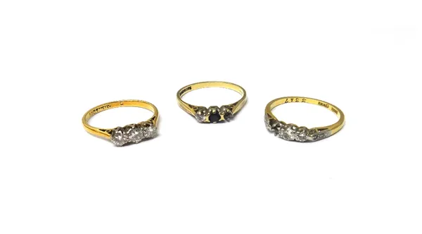 A gold and platinum ring, claw set with a row of three circular cut diamonds, a gold and platinum ring, mounted with two principal circular cut diamon