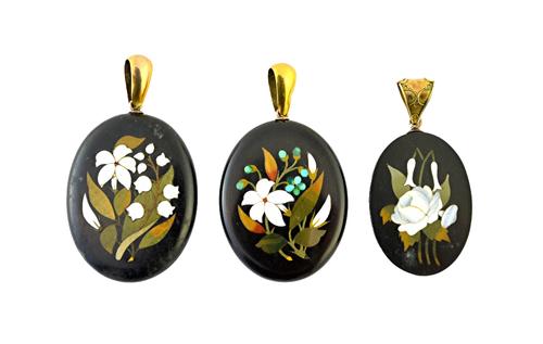 An oval pietra dura pendant, with floral decoration and two oval pietra dura pendants, each with a locket compartment at the back.  Illustrated
