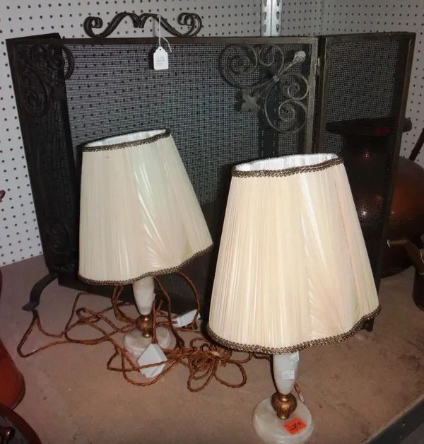 A pair of 20th century onyx and brass lamps, together with a 20th century metal fire guard.