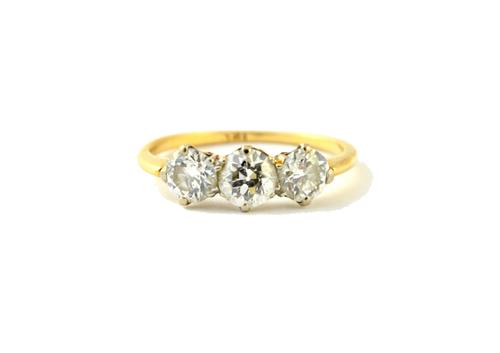 A gold and diamond set three stone ring, claw set with a row of cushion shaped diamonds, detailed 18 CT, ring size S.  Illustrated