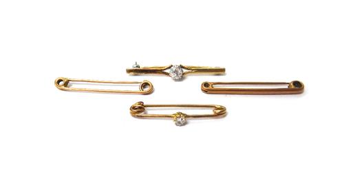 A diamond set single stone bar brooch, claw set with a cushion shaped diamond between split sides, a diamond set single stone safety pin brooch, claw