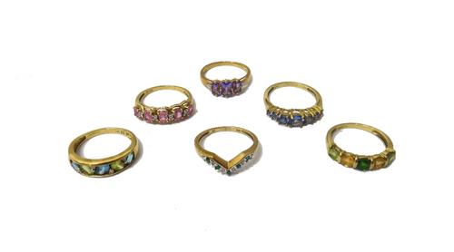 A 9ct gold ring, mounted with five circular cut emeralds, alternating with six small circular cut diamonds, in a 'V' shaped design and five further 9c