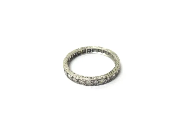 A platinum and diamond set full eternity ring, mounted with circular cut diamonds, the band with engraved decoration, ring size Q.