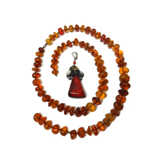 A single row necklace of irregular mostly translucent amber beads and a moonstone, citrine and gem set pendant, with a tapering reconstituted amber dr