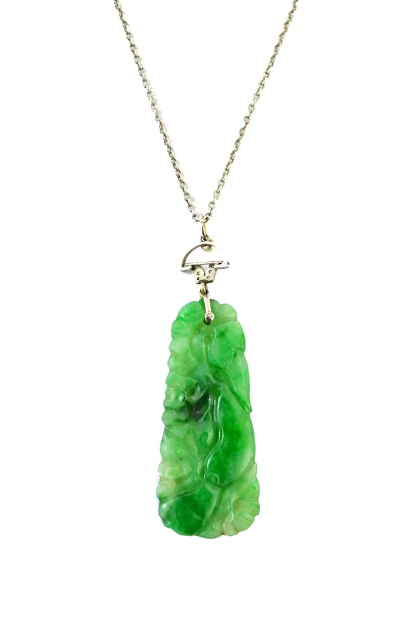 A carved jade pendant, in a tapering panel shaped design, decorated with fruit and foliage and with a rose diamond and seed pearl set suspension, with