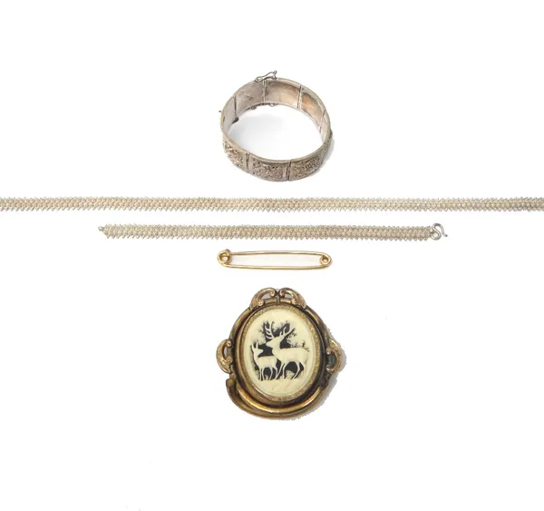 An 18ct gold safety pin brooch, weight 6.9 gms, a Victorian shaped oval brooch, carved with two deer in a forest setting, an Oriental panel link brace