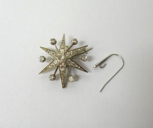A diamond set brooch, designed as a six pointed starburst with diamond set single stone divisions at intervals, mounted with cushion shaped and rose c