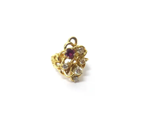 A gold, diamond and ruby set ring, claw set with a circular cut ruby and with five circular cut diamonds, in a pierced abstract design, with a rustic