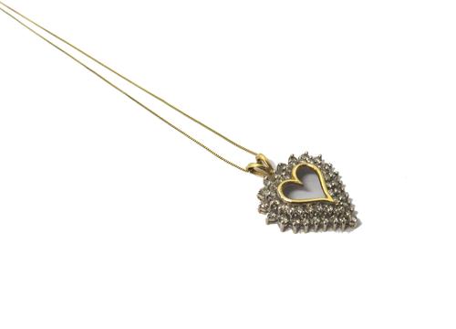 A gold and diamond set pendant, pierced in an openwork heart shaped design mounted with two rows of circular cut diamonds, detailed 10 K, on a gold ne