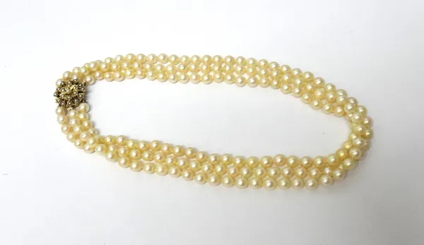 A three row necklace, of uniform cultured pearls, on a gold and cultured pearl set cluster clasp, with an Asprey case.