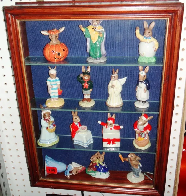A group of fourteen Royal Doulton Bunnykins models, contained in two wall mounted display cases.