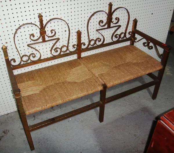 A gold painted wrought iron two seat bench with rush seat, 108cm wide.