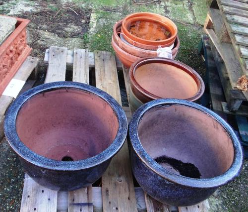 A group of eight assorted stone and terracotta pots.