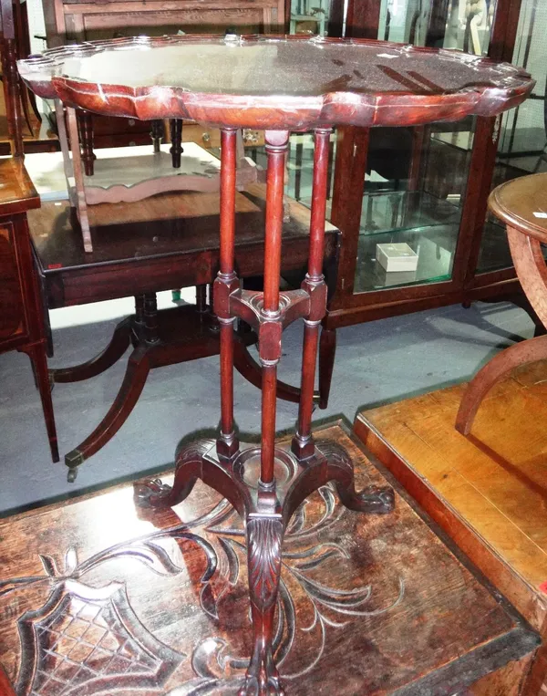 A mahogany occasional table, with shaped top over three columns and tripod base.