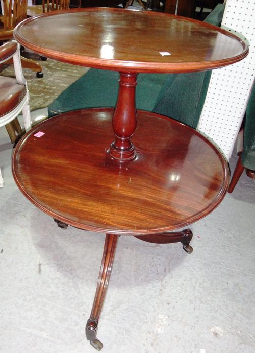 A George III mahogany graduated circular two tier dumb waiter on tripod base, 65cm wide.