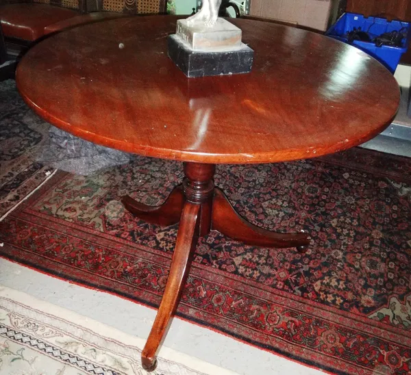A George III mahogany circular snap top table on tripod base.