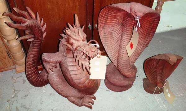 A 20th century carved wooden cobra, another smaller and a dragon.