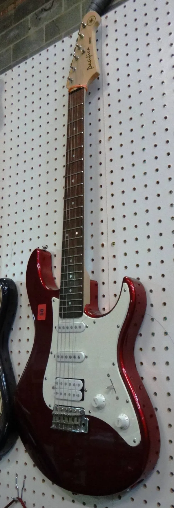A Yamaha dark red electric guitar.